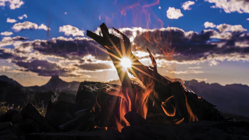 bone fire beside mountain with cloudy sky