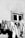 Clothes hang on a line strung across the exterior of a building, positioned below a single window. The wall appears to be weathered, and the garments, captured in monochrome, exhibit a range of textures and creases as they are draped over the line.