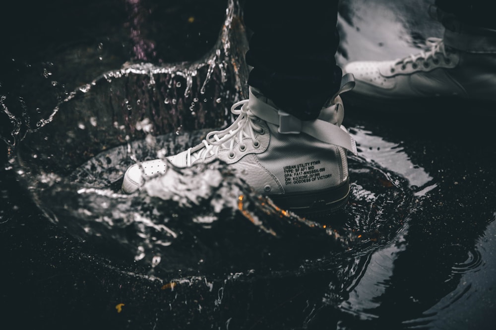 Graustufenfotografie einer Person, die auf dem Wasser steht