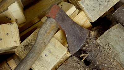 A rustic axe with a wooden handle resting on reclaimed wood planks.