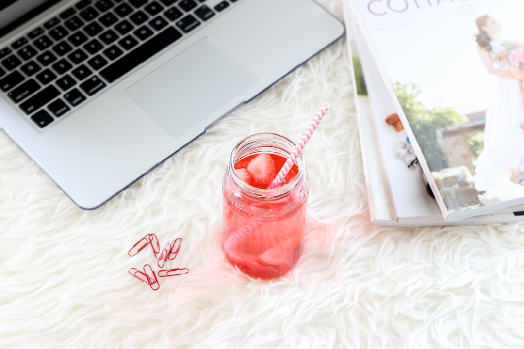 clear mason jar with red liquid and straw