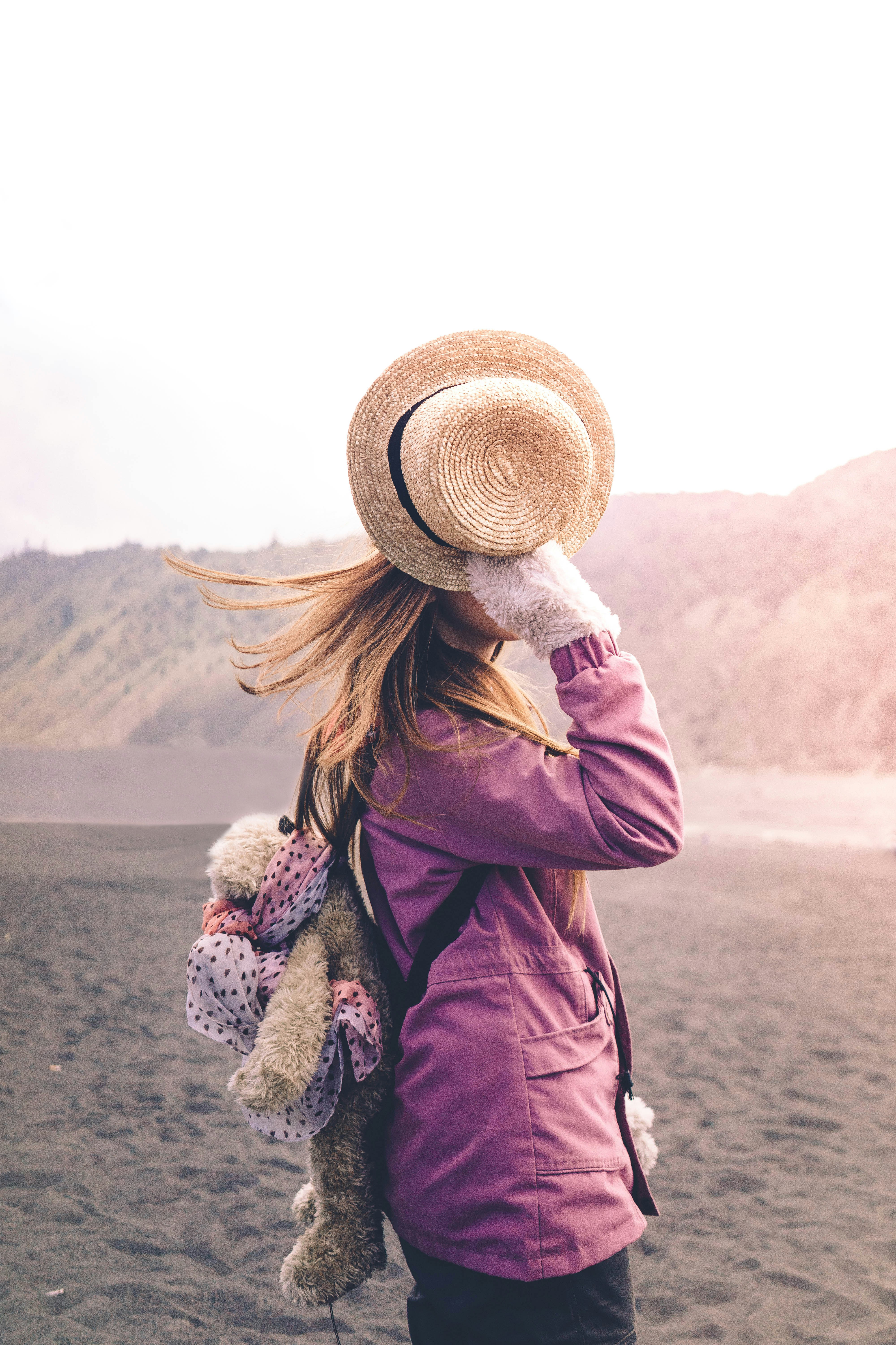 woman holding his brown hat