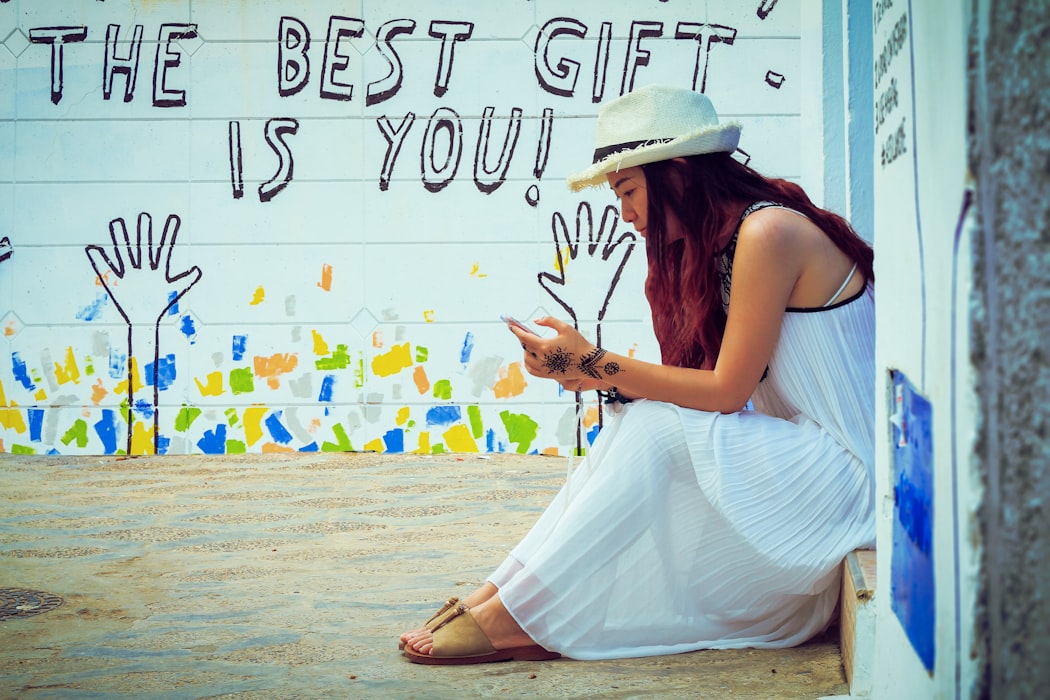 sitting woman, white wall, graffiti