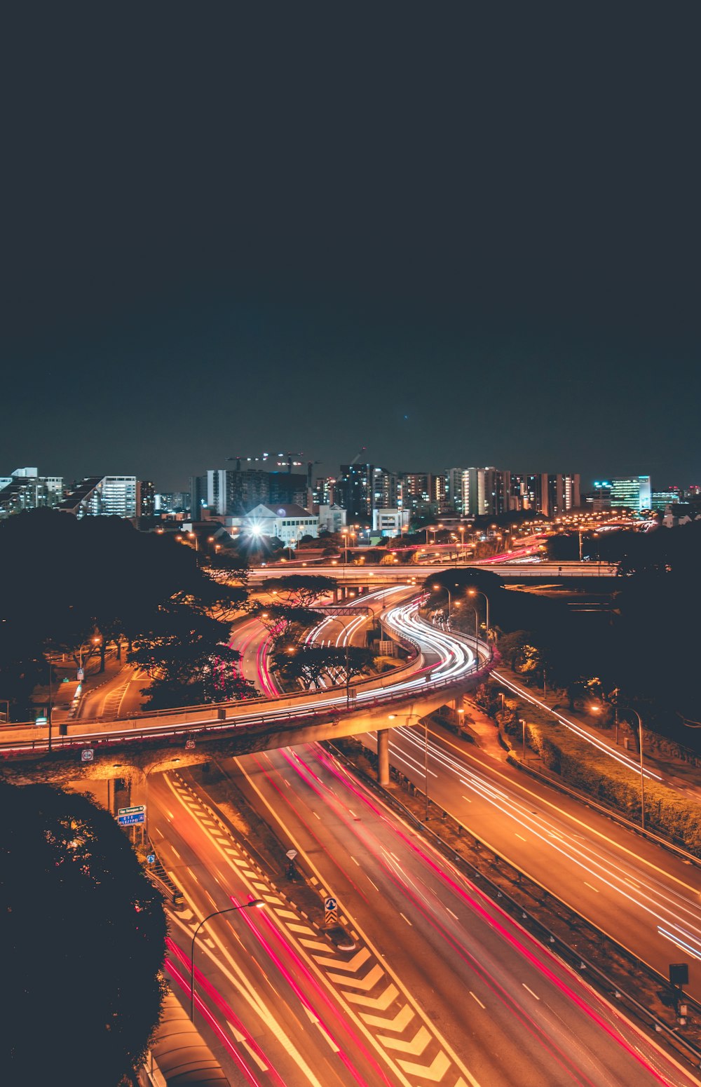 time-lapse photography of road near buildings during nighttime aerial photo