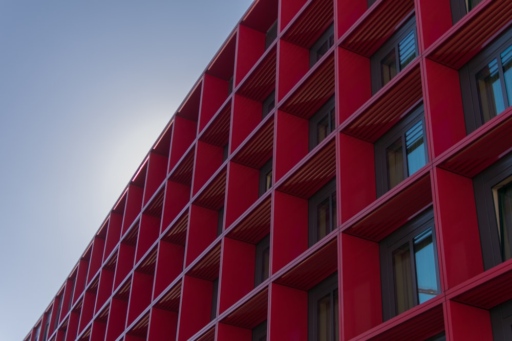 Fotografía de ángulo bajo de un edificio rojo de gran altura