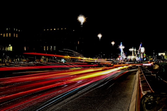 timelapse photography of vehicle lights crossing on road near city during nighttime in Bordeaux France