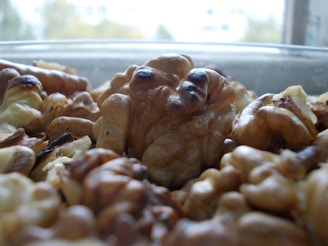 A close-up of fresh walnuts in a wooden bowl.