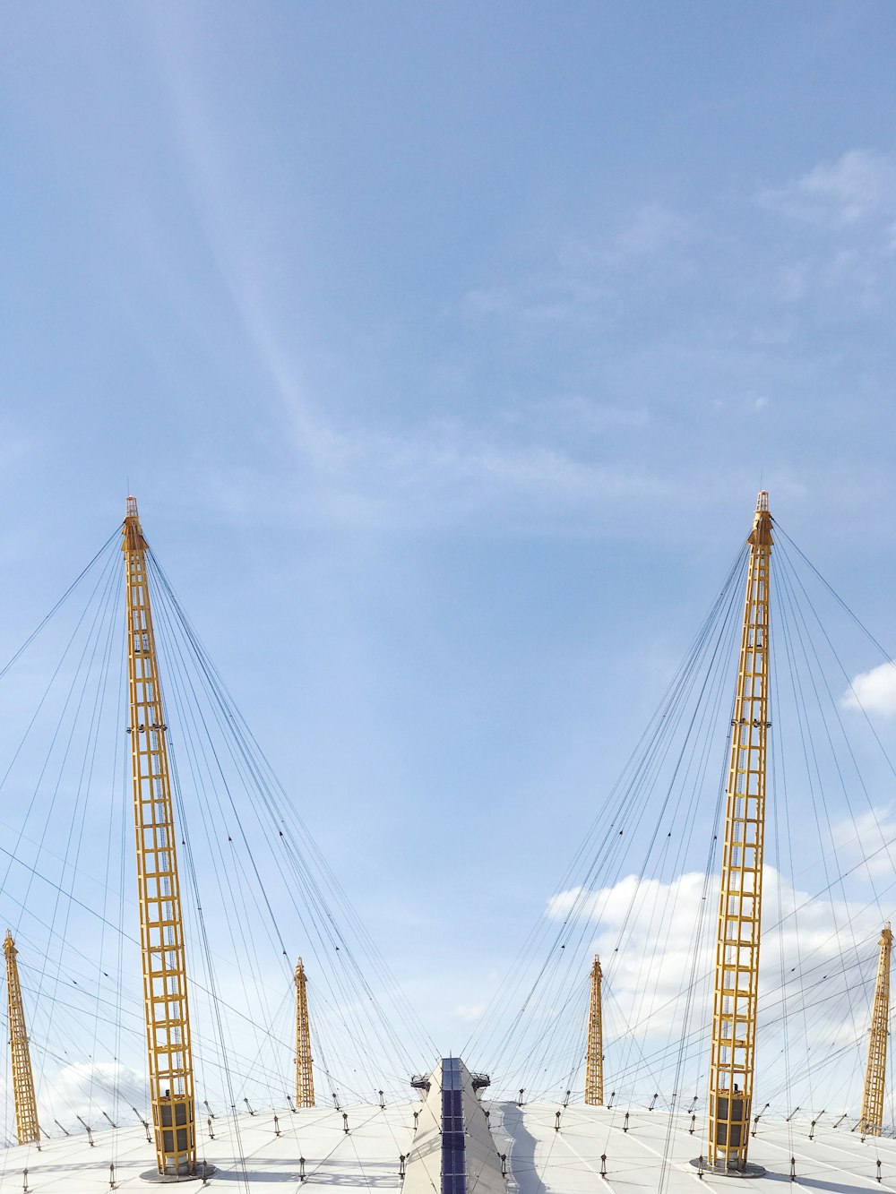 two yellow cable towers under blue sky