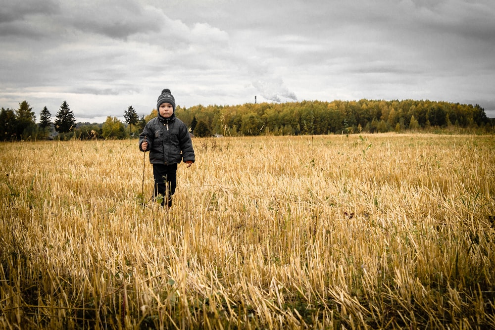 person standing on rice field under white sky at daytime