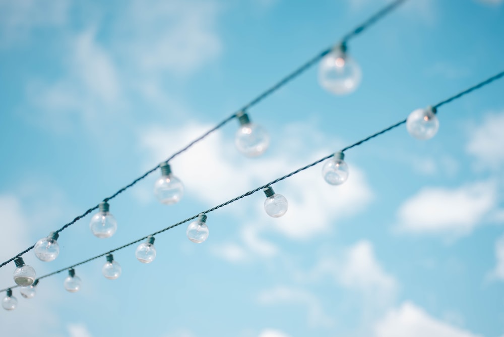 tilt lens photography of string lights under cloudy skies