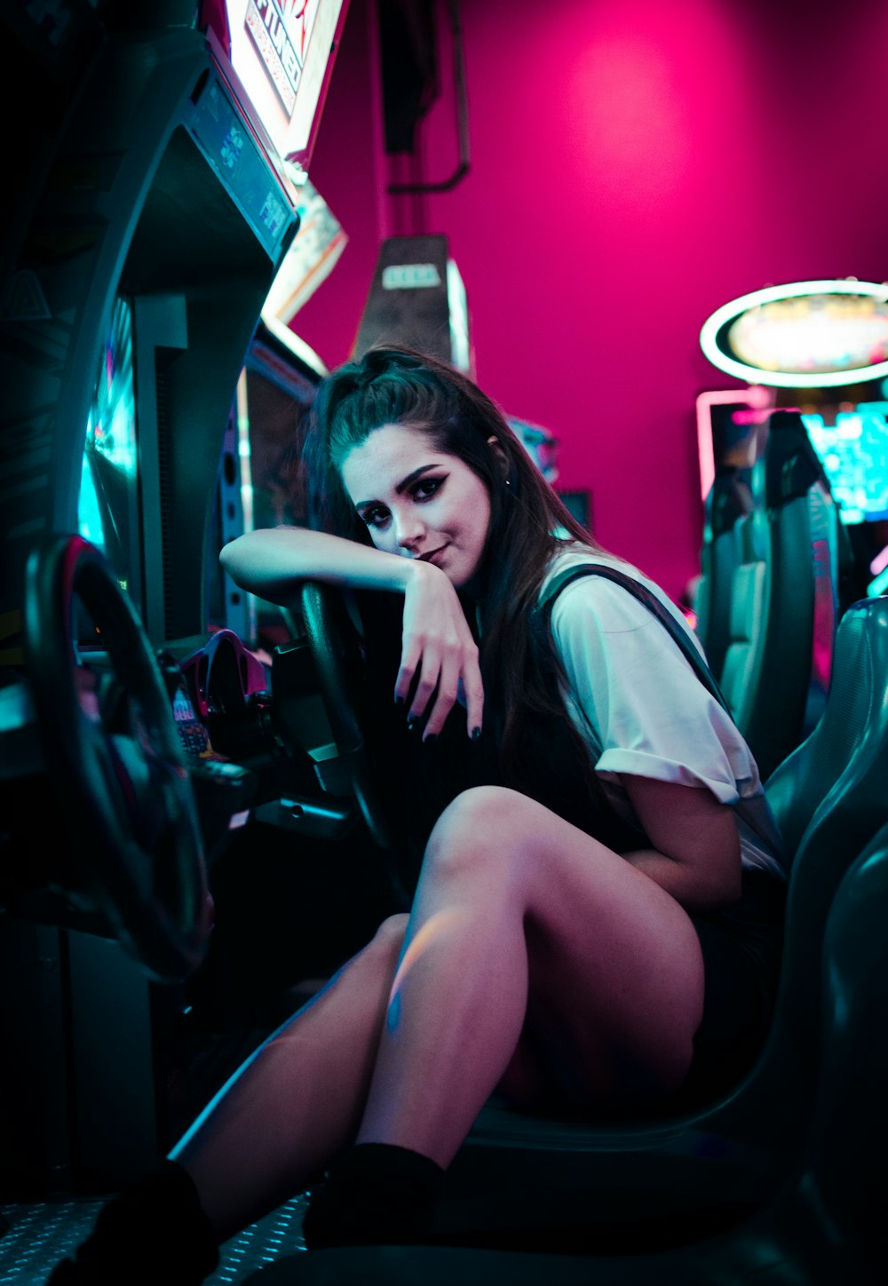Donna che si siede sulla macchina arcade dell'automobile