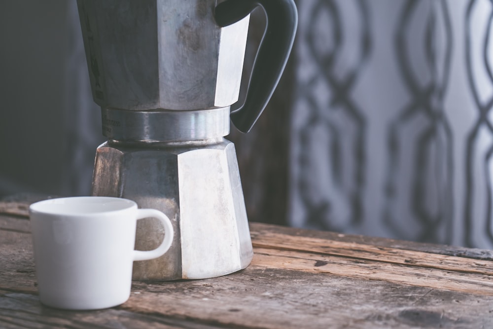 white mug beside moka pot