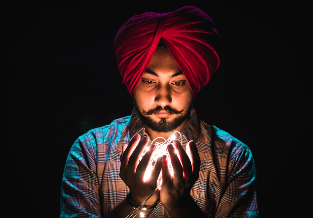 man holding string lights