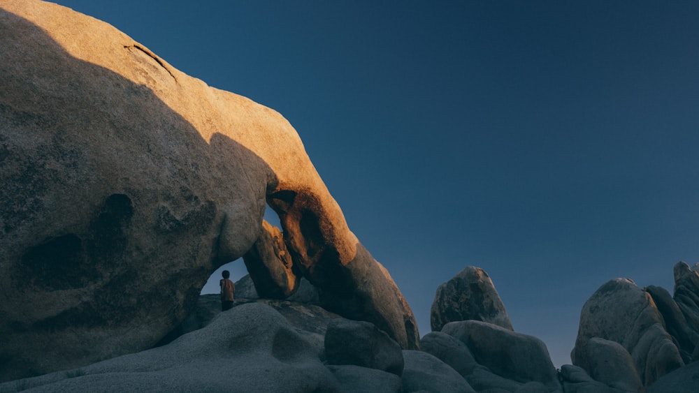 brown natural arch under clear sky