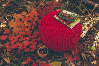 A vibrant blue knitted pouf adding a pop of color to a modern lounge area.
