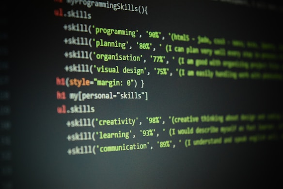 Lines of code are displayed on a dark screen, showing a set of skill percentages related to programming, planning, organization, visual design, creativity, learning, and communication. The text is colored, likely to indicate syntax highlighting in a code editor.