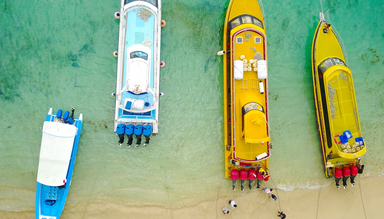 aerial photography of four boats on seashore