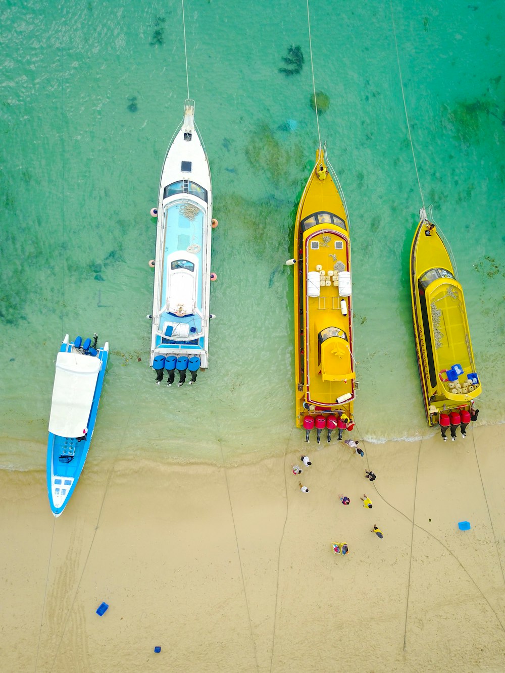 aerial photography of four boats on seashore