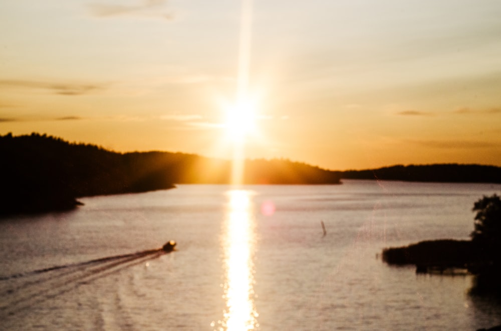 boat running on sea during golden hour