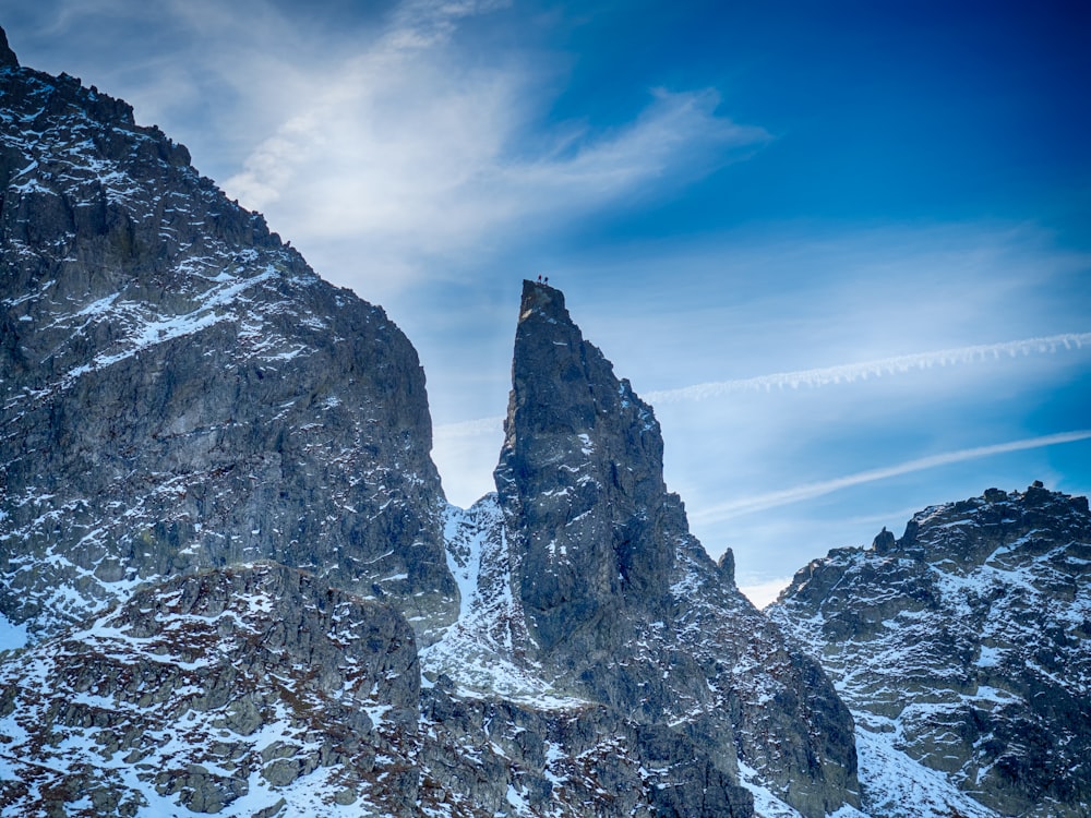 people standing on top black and white snowy mountain