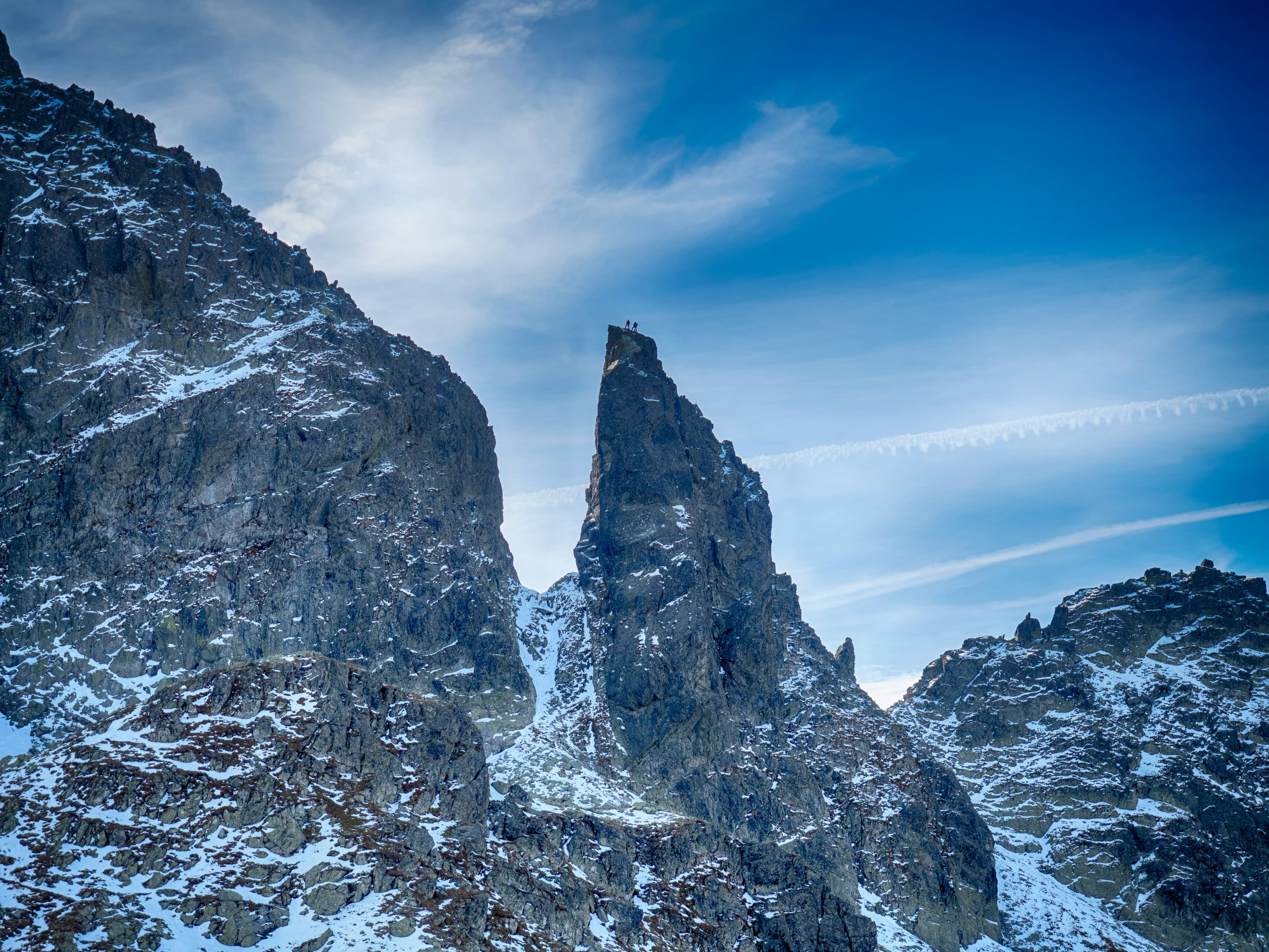 people standing on top black and white snowy mountain