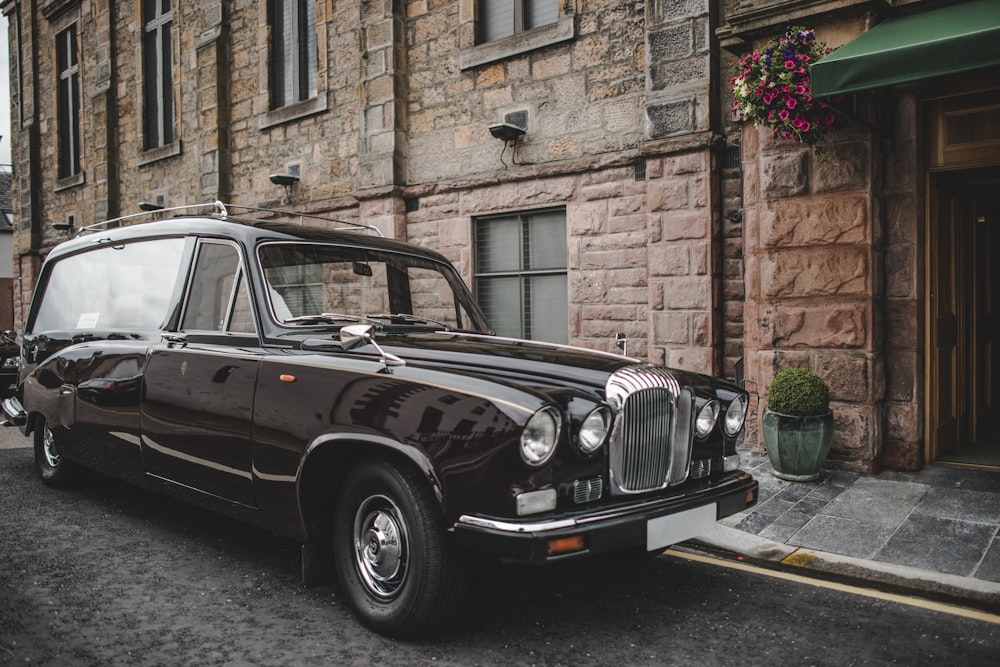 vintage black car beside building at daytime