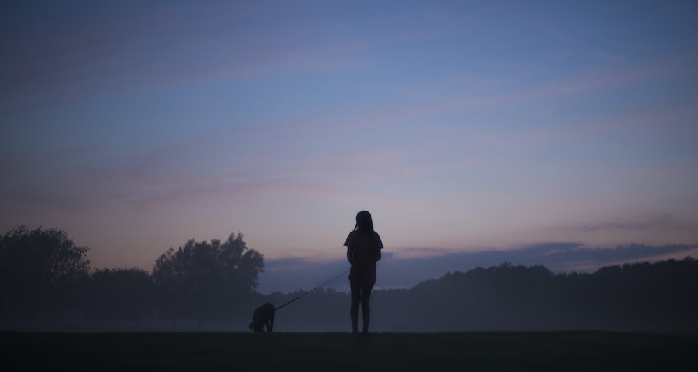 silhouette person standing holding dog