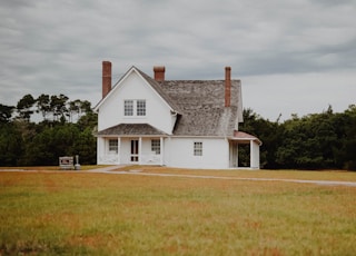 structural shot of white and gray concrete house under cloudy sky