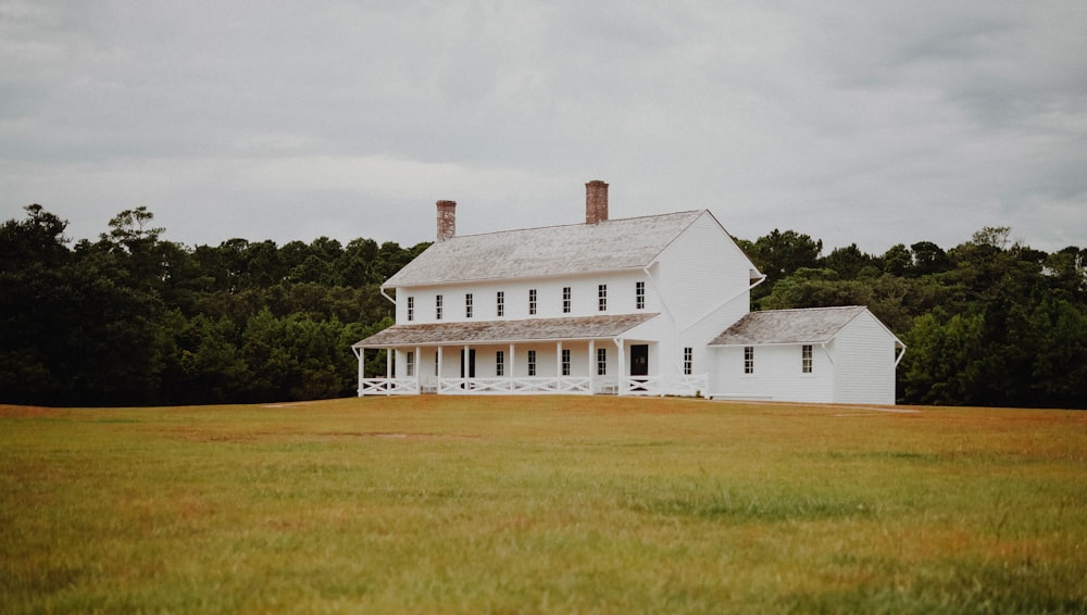 Weißes und braunes Haus auf grüner Wiese tagsüber