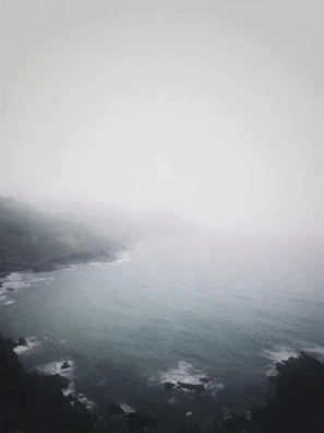 A misty coastal horizon where ocean meets sky in gentle embrace.