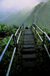 man walking on gray ladder on hill
