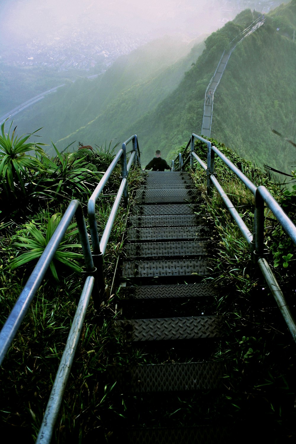 man walking on gray ladder on hill