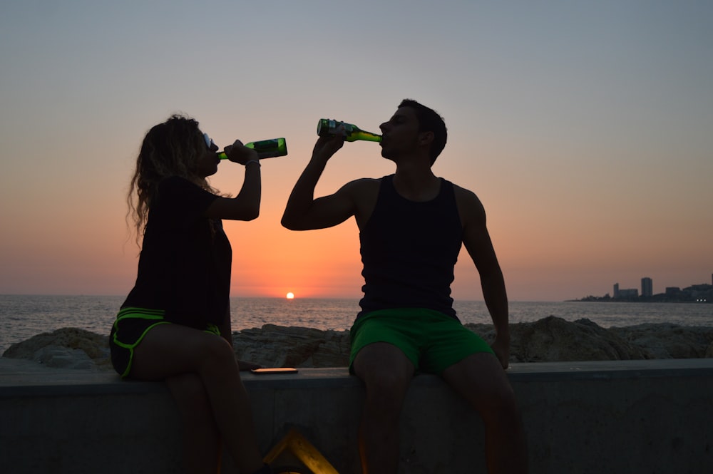 mujer y hombre sosteniendo botellas para beber