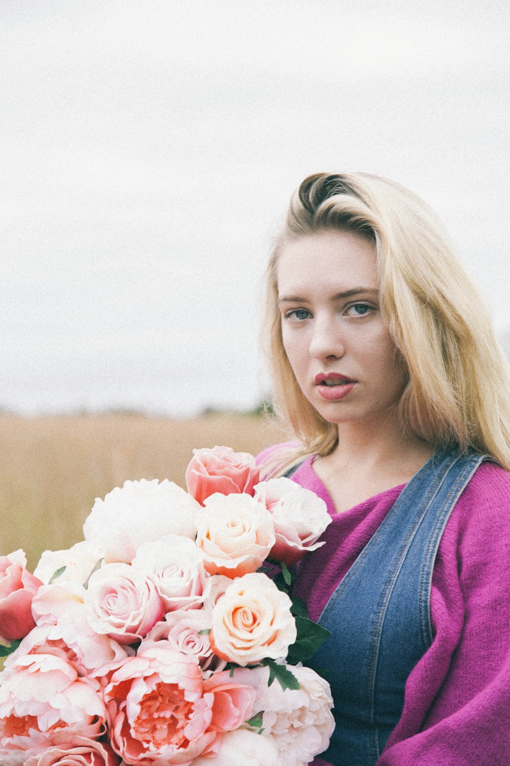 woman holding pink flower bouquet