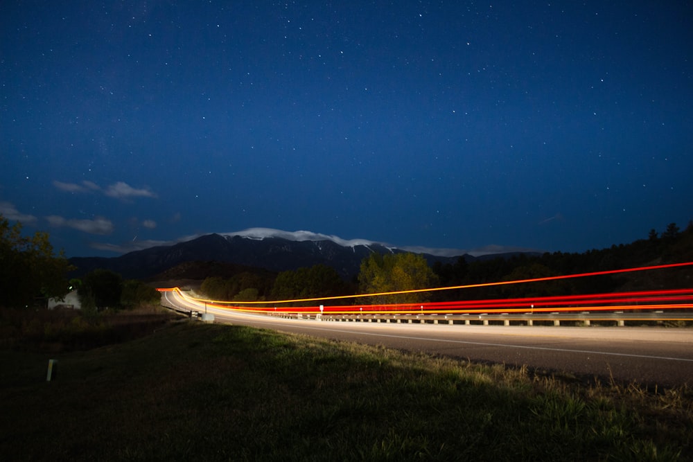 time lapse photograph of train under starry sky
