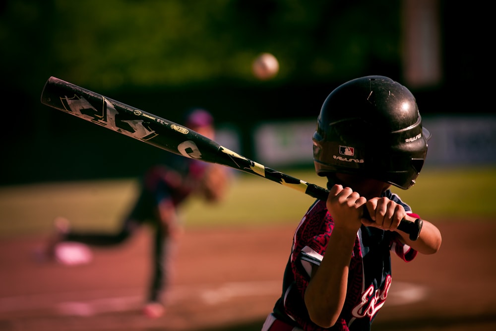 fotografia di messa a fuoco selettiva di persona che tiene mazza da baseball