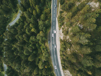 A drone shot of the winding Carretera Austral road surrounded by lush forests