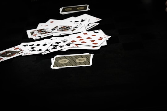 A close-up of shuffled cards spread out on a dark table.