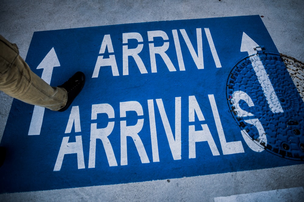 person standing on arrivals sign