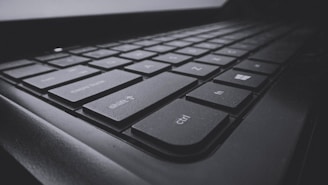A close-up view of a black computer keyboard displaying several keys in focus, including shift, ctrl, and windows keys. The image emphasizes the texture and design of the keys with a slightly dark and moody atmosphere.