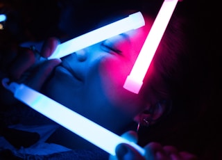 woman holding white LED light inside dark room