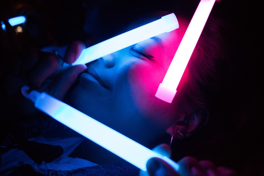 woman holding white LED light inside dark room