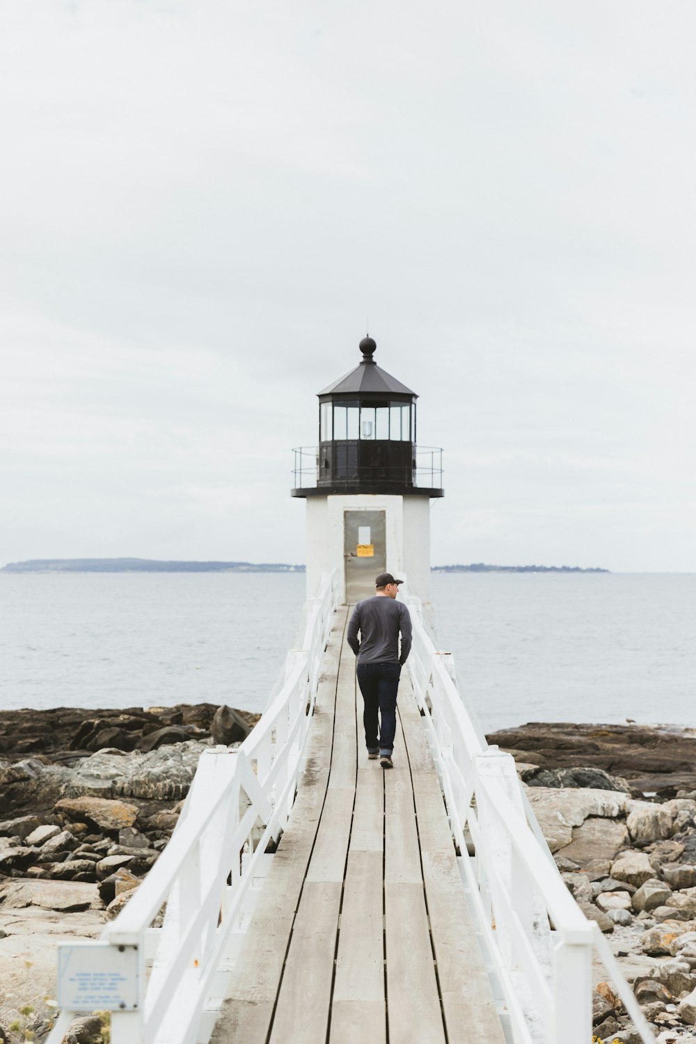 man in gray top walking on dock bridge