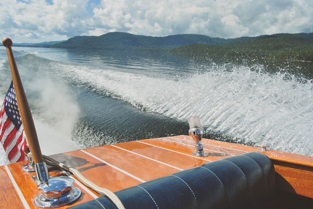 brown speedboat on top of body of water