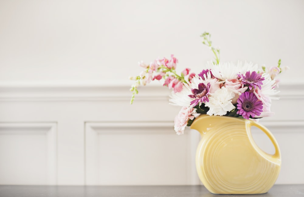 white and purple flowers on white ceramic vase