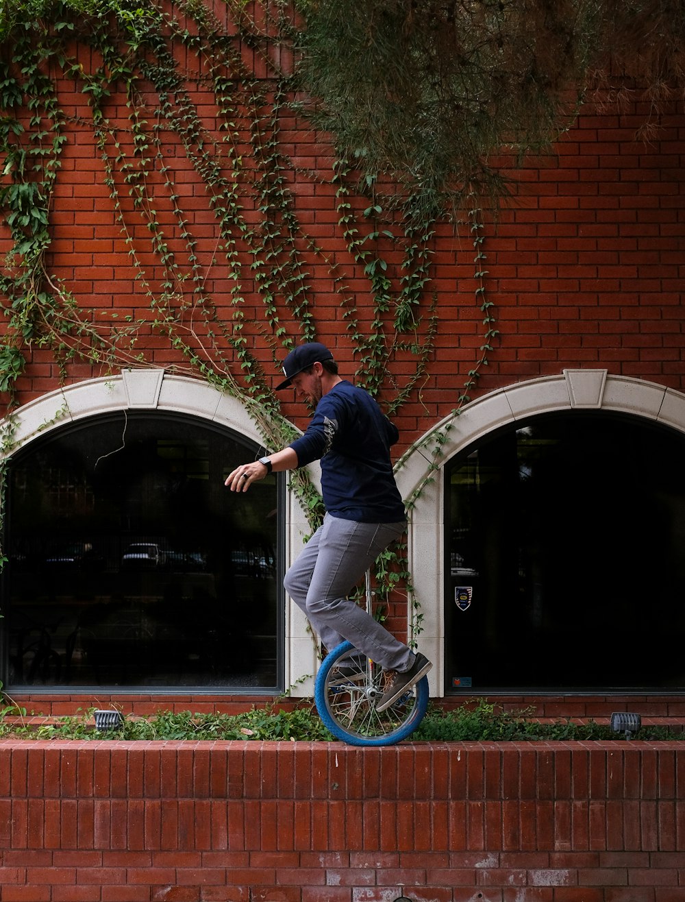 Homem montando monociclo perto da parede