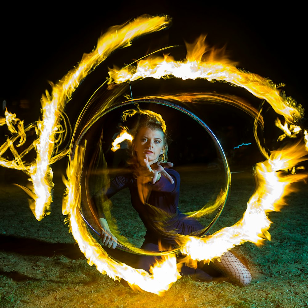 woman kneeling on ground with fire effect