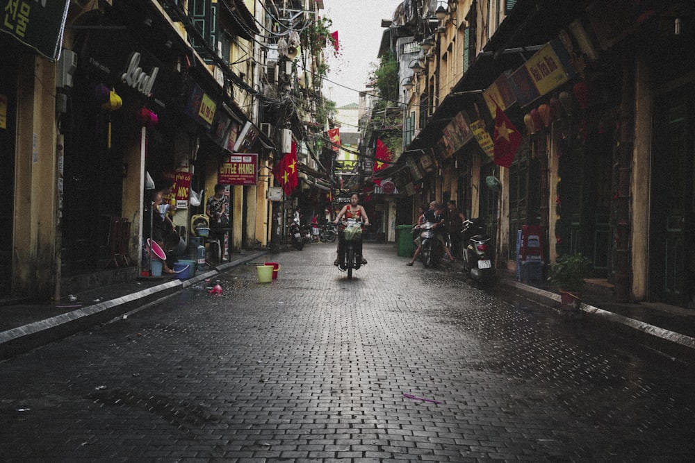 person riding motor scooter near building