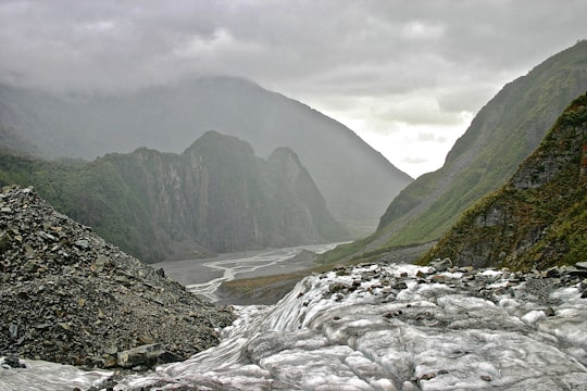 stream near mountains during day in Fox Glacier New Zealand