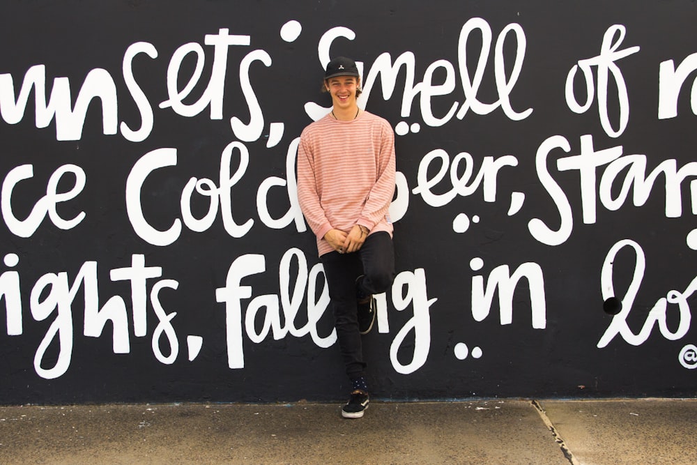 man leaning on wall